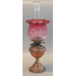 Early 20th Century double oil burner having clear glass chimney above an etched cranberry glass