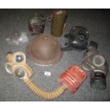 Box containing three vintage and one modern gas mask, together with a Second World War helmet and