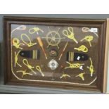 Decorative framed and glazed panel on nautical theme with knots, insignia and other items. 40 x 60cm