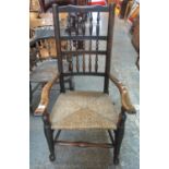 Yorkshire style stained spindle back open armchair on rush seat with turned legs and shaped