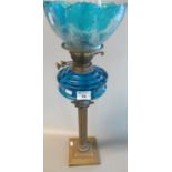 Brass double burner oil lamp with coloured glass reservoir on brass fluted column with square