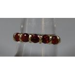 9ct gold stone set dress ring with five red stones, probably garnets. 2.2g approx. (B.P. 21% + VAT)