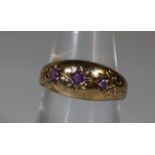 9ct gold three stone dress ring, set with three small probably amethyst stones. 3.2g approx. (B.P.