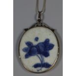 Chinese blue and white porcelain shard set as an oval pendant within a silver pendant mount.