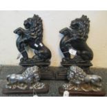 Pair of white metal doorstops in the form of handed lions, together with two black cast metal