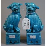 Pair of blue glazed Chinese design miniature dogs of fo or temple dogs on pedestals, 15cm high