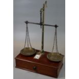 Pair of brass apothecary scales on mahogany drawer base. 41 cm high approx. (B.P. 21% + VAT)
