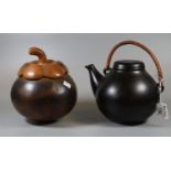 Finnish 'Arabia' black ground pottery lidded teapot with wicker handle, together with an unusual art