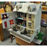 Large dolls house with an extensive amount of accessories: bedroom furnishings, figures, lighting,