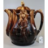 Large brown ground treacle glazed pottery lidded water jug or teapot with moulded decoration of