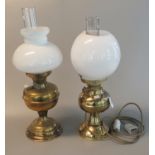 Two similar brass oil lamps, one converted to electricity. Both with opaque glass shades and clear