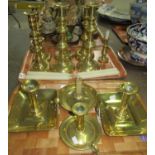 Two trays of brass candlesticks to include: three pairs of candlesticks and four bedside candle