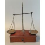 Pair of brass apothecary scales on mahogany drawer base. 41 cm high approx. (B.P. 21% + VAT)