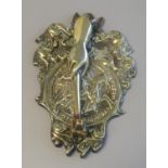 Heavy door knocker with relief brass back plate featuring mounted knight amid scroll work, with