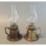 Near pair of similar brass single burner oil lamps with baluster clear glass chimneys and squared