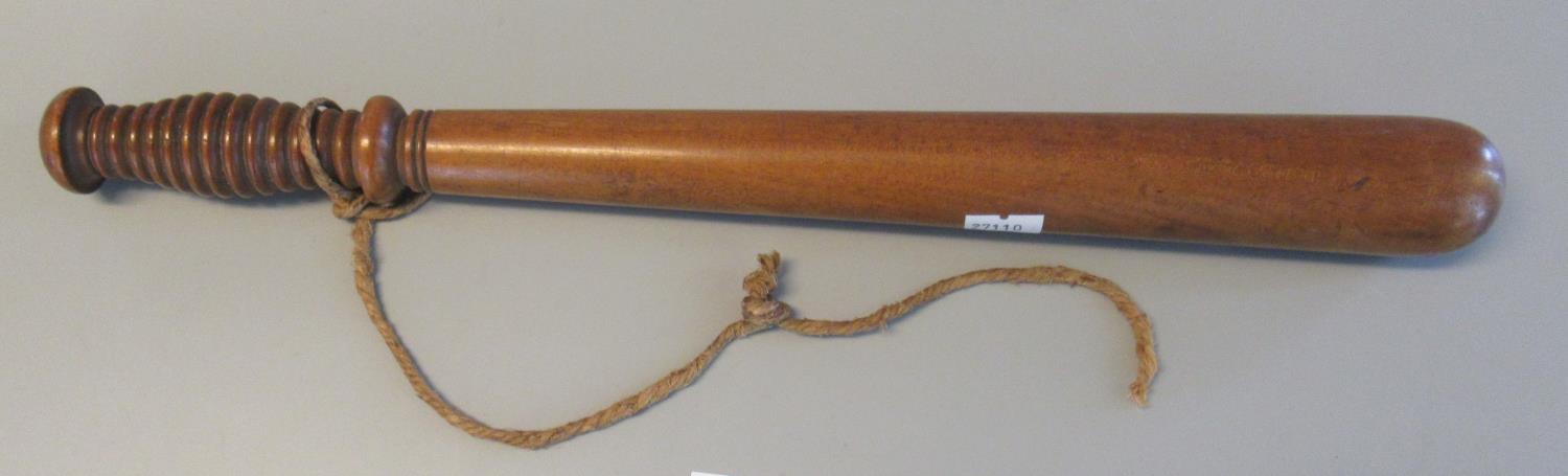 Turned hardwood truncheon with cord wrist loop. 40.5 cm approx. (B.P. 21% + VAT)