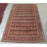 Middle Eastern design carpet on a red and blue ground with central medallions of foliage flanked