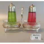 A pair of mid Century glass sugar sifters, one in cranberry glass, the other in green glass, mounted