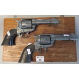 Pair of diecast metal replica colt revolvers on wooden display panel. (2) (B.P. 21% + VAT)