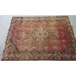 Middle Eastern design salmon and brown ground carpet with central floral medallion flanked by