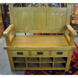 Modern pale oak hall bench with open arms above three fitted drawers and eight compartments. (B.P.