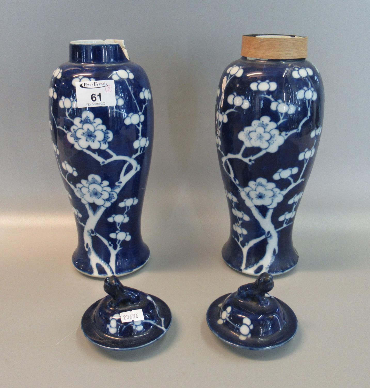 Pair of Chinese porcelain blue and white baluster lidded vases with Fo dog finials and a prunus on