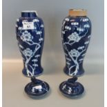 Pair of Chinese porcelain blue and white baluster lidded vases with Fo dog finials and a prunus on