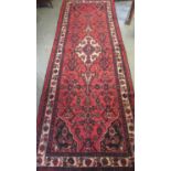 Red ground Persian Surok floral and foliate runner. 310 x 105cm approx. (B.P. 21% + VAT)