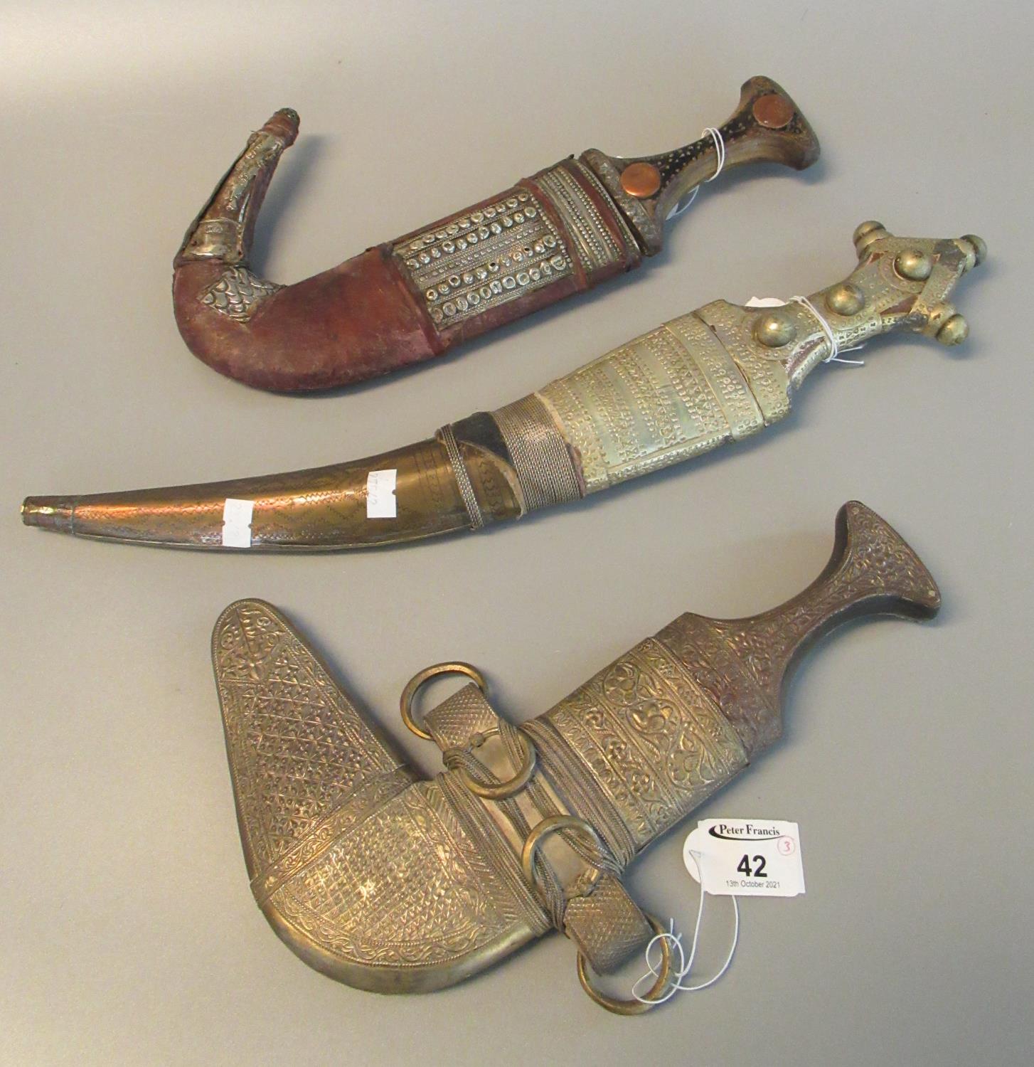Three Arab type Jambiya daggers with white metal mounts. (3) (B.P. 21% + VAT) These items cannot