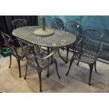 Modern weathered metal pierced garden table with a set of six matching chairs and parasol stand. (