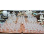 Five trays of good quality cut glass crystal drinking glasses and decanters, some etched with leaf