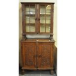 Unusual probably continental oak two stage cabinet back bookcase, the panels carved with a rose