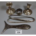 A bag of assorted silver items to include; a pair of dwarf candlesticks, napkin ring, vanity