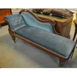 Late Victorian walnut upholstered button back show frame chaise lounge on tapering legs and castors.