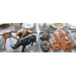 Two trays of carved items to include: two tribal masks, two Indonesian face carvings, an elephant,