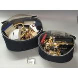 Two black vanity cases comprising assorted jewellery, various gold plated bracelets, bangles,