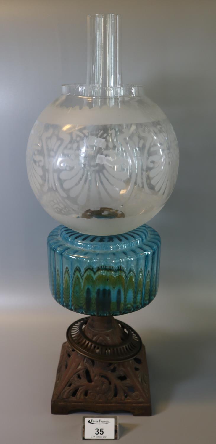 Early 20th Century oil burner having etched globular foliate shade, aqua reservoir on a cast metal