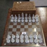 Modern glass chess set with glass plain surface, together with an Eastern carved wooden, rectangular