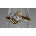 18ct gold three stone diamond ring set on a twist. Ring size K. Approx weight 2.6 grams. (B.P. 21% +