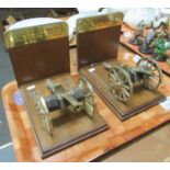 Pair of bookends adorned with models of cannons from the battle of Waterloo on finished oak bases,