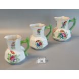 Three graduated Dillwyn, Swansea octagonal pouch-shaped jugs with painted floral decoration, one