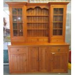 Large modern pine two stage dresser, the moulded cornice flanked by two glazed cabinets and