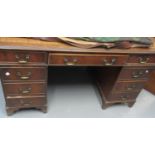 Early 20th Century mahogany knee hole desk, the leather inset top above three drawers to each