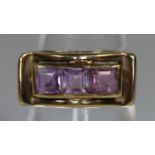 Yellow metal three stone amethyst ring. Ring size K. Approx weight 3.3 grams. (B.P. 21% + VAT)