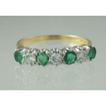18ct gold emerald and diamond half eternity style ring of four emeralds and three diamonds. Ring