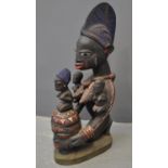 West African female polychrome decorated carved wooden offertory figure of mother with three