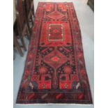 Middle Eastern design Brojerd runner on a red and blue ground with central medallions decorated with