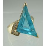 14ct gold blue topaz and diamond ring. The triangle cut blue topaz having one diamond set