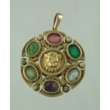 A 19th century circular yellow metal pendant decorated with a raised and engraved lion's head to the