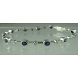 A sapphire and diamond line bracelet set in white gold. Length 7.5 inches (19cm). Approx weight 11.8